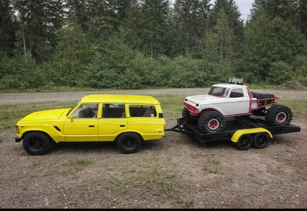 Keltainen Land Cruiser ja valkoinen kuorma-auto RC-lavettikärryllä