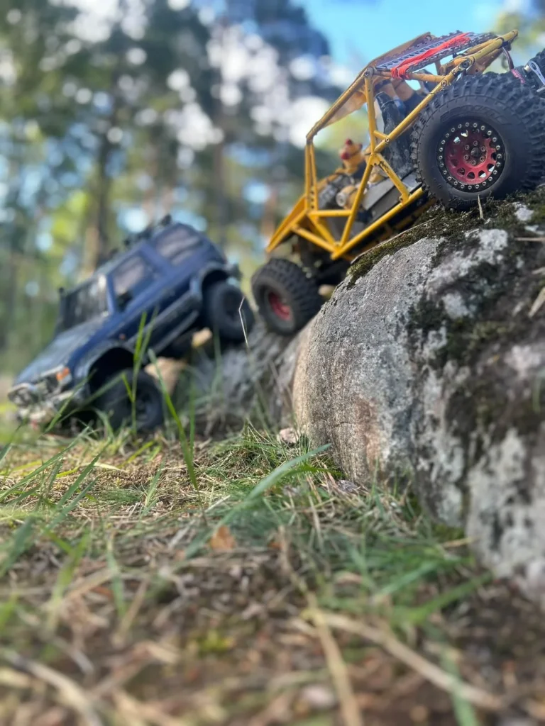 Keltainen putkirunkobuggy kiven päällä, sininen crawler taustalla