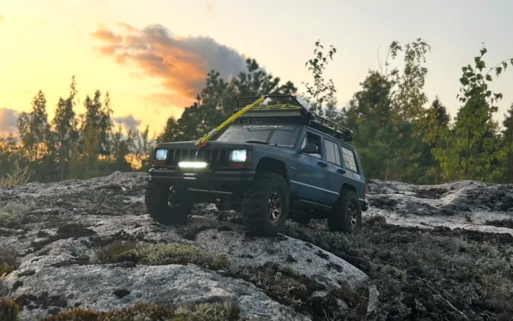 Sininen Cherokee-crawler kalliolla auringonlaskussa