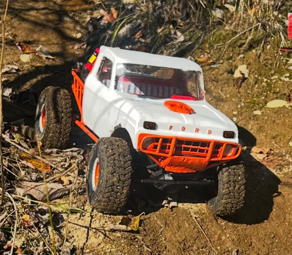 Valko-oranssi Ford-crawler maastossa
