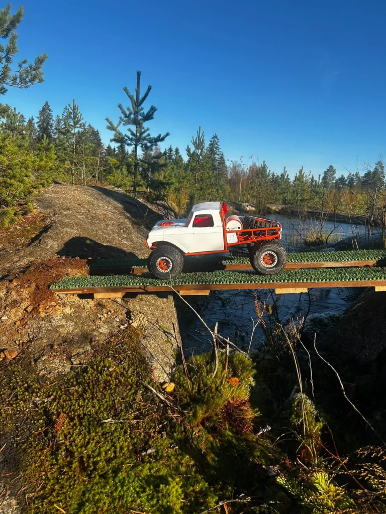 Valkoinen RC-pickup ylittää lankkusillan