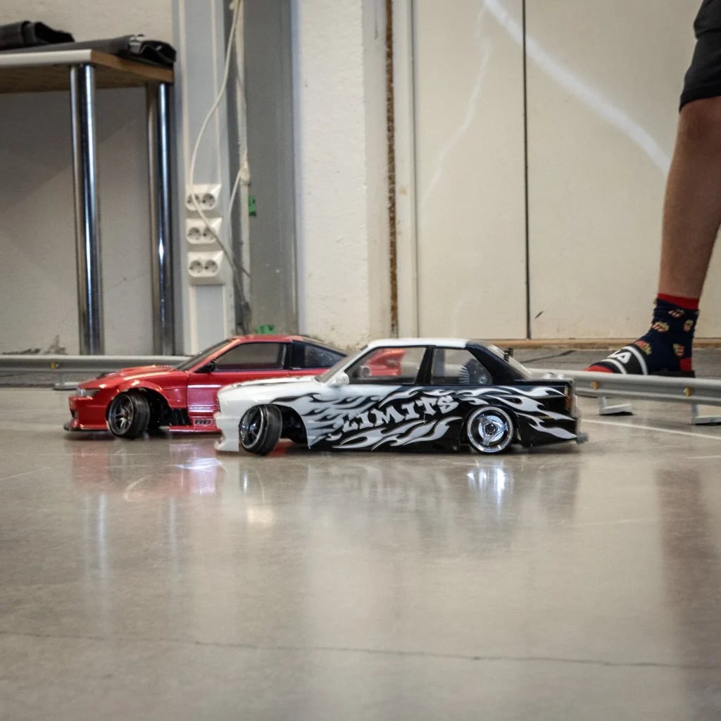 RC-drift-autoja radan reunalla kerhotilassa
