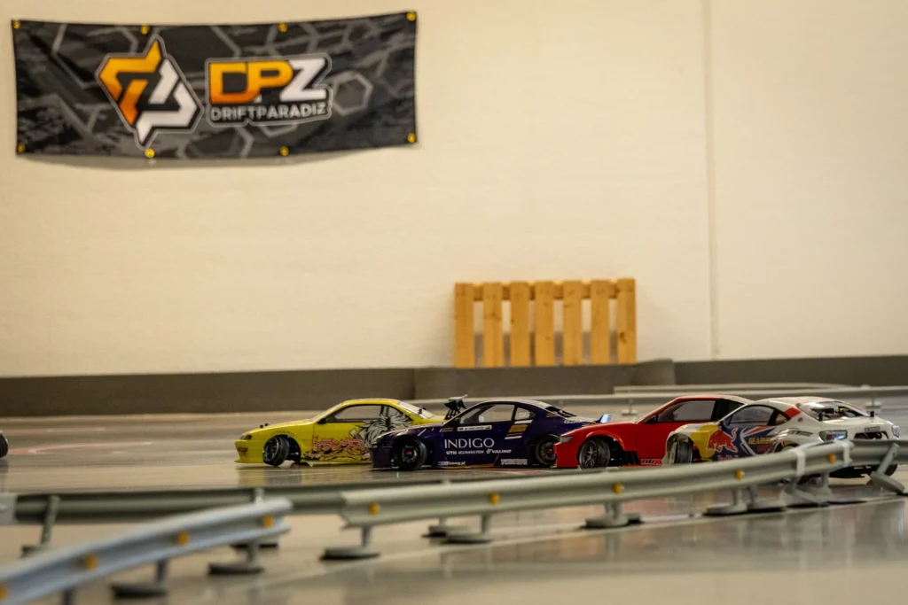 RC-drift-autoja radalla, taustalla Drift Paradise -banneri