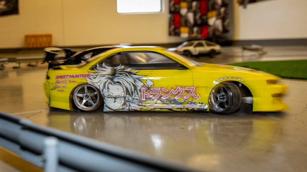 Keltainen RC-drift-auto sivusta kuvattuna radalla