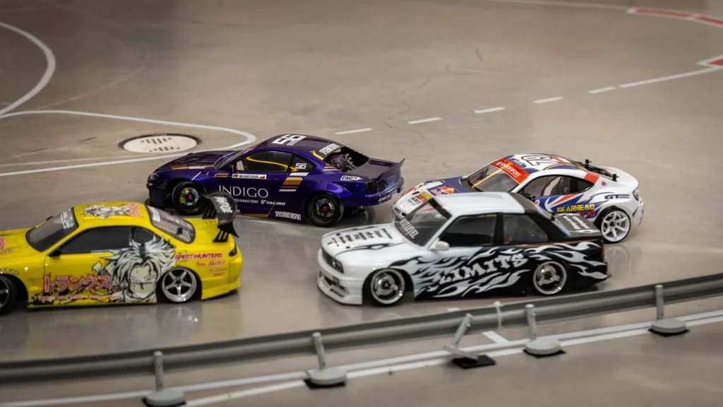 Kolme RC-drift-autoa radalla kerhotilassa