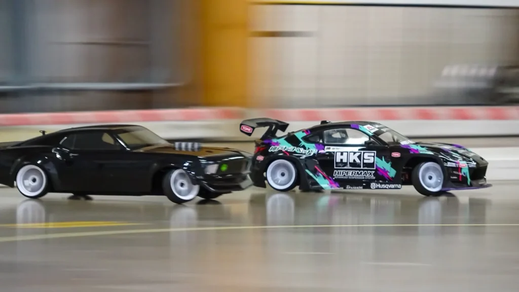 Kaksi RC-drift-autoa peräkkäisajossa sisäradalla