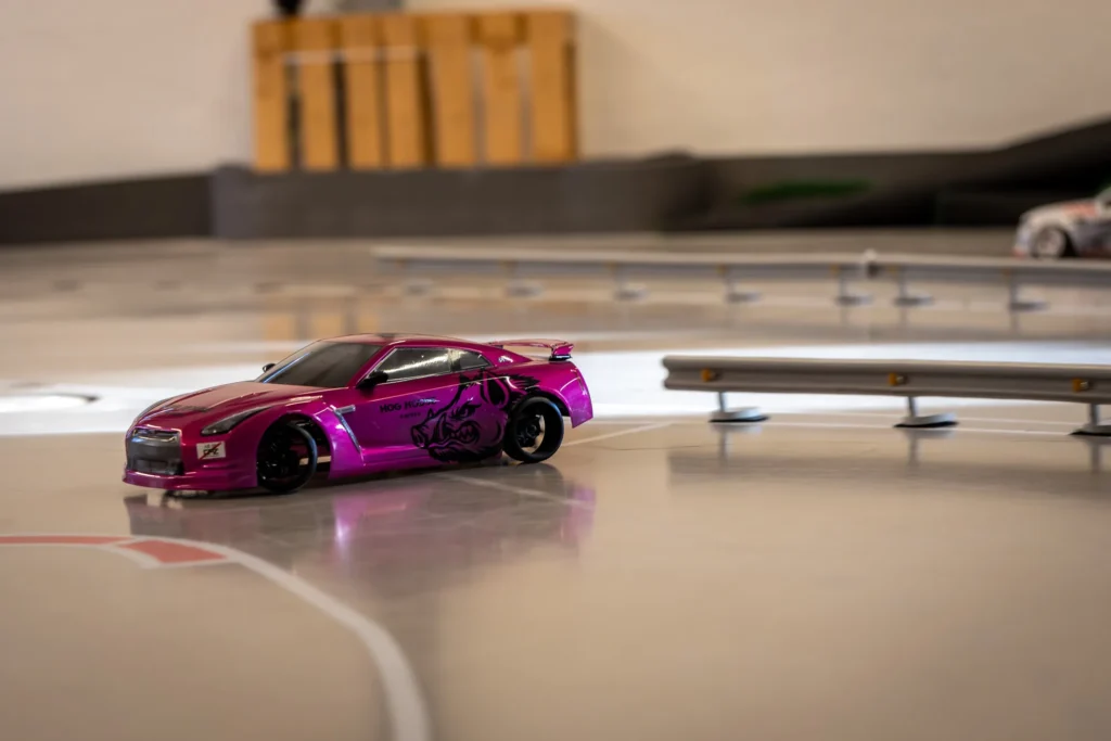 Pinkki RC-drift-auto radan kaarteessa kerhotilassa